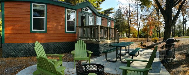 Deluxe Cabin surrounded by colorful autumn trees at Elizabethtown / Hershey KOA Holiday in Central Pennsylvania
