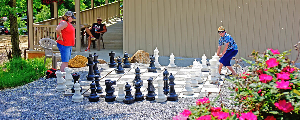 Family playing giant outdoor chess together at Elizabethtown / Hershey KOA Holiday