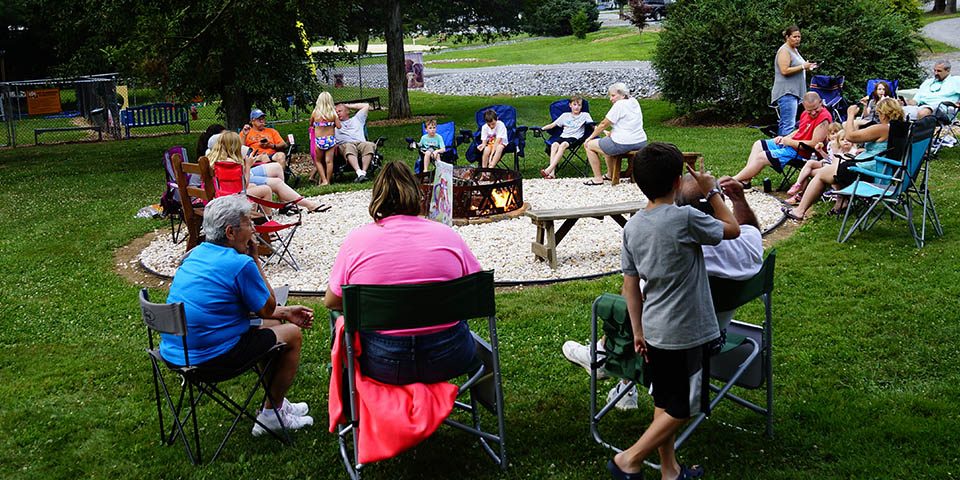Why Families Return to Elizabethtown / Hershey KOA Year After Year Families gathering around a campfire at Elizabethtown / Hershey KOA Holiday