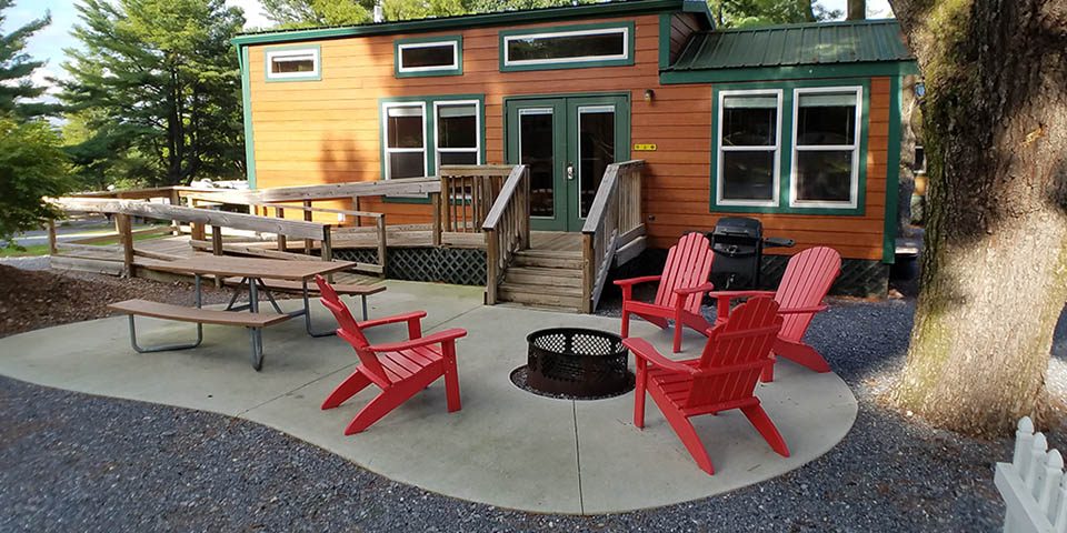 Deluxe Cabin with private fire pit, picnic table, grill, and outdoor seating at Elizabethtown / Hershey KOA Holiday near Hershey, Pennsylvania