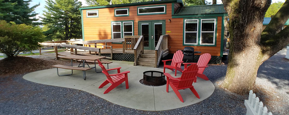 Deluxe Cabin with private fire pit, picnic table, grill, and outdoor seating at Elizabethtown / Hershey KOA Holiday near Hershey, Pennsylvania
